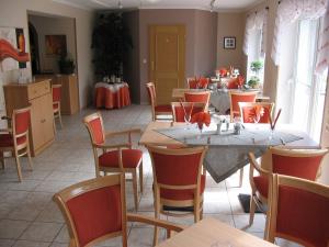 ein Restaurant mit Tischen und Stühlen in einem Zimmer in der Unterkunft Parkhotel Phoenix Garni in Hage