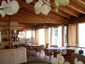 a dining room with tables and chairs and windows at Hotel Club Ragno D'oro in Aglientu