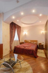 a bedroom with a bed and a glass table at Ghostinitsa "Lina" in Petropavlovsk