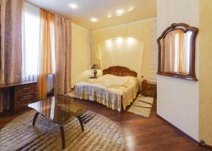 a bedroom with a bed and a table and a mirror at Ghostinitsa "Lina" in Petropavlovsk