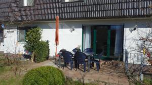 um grupo de cadeiras e uma mesa em frente a uma casa em Ferienwohnungen Göhren em Göhren