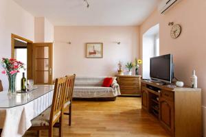 een woonkamer met een televisie en een bank bij Apartment Ana in Split