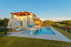 a house with a swimming pool in the yard at Villa Rajski Dvori in Sveti Lovreč Pazenatički