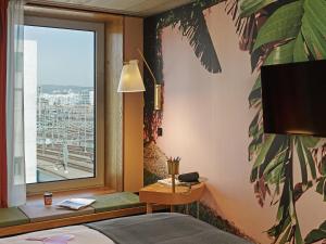 a hotel room with a window overlooking the ocean at 25hours Hotel Langstrasse in Zurich