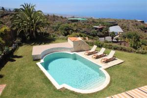 Los CarrizalesにあるApartment Leon Finca Montimarの海と椅子のある庭のスイミングプール