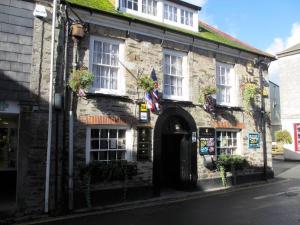 an old stone building with a flag in front of it at Ship inn in St Austell