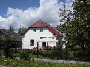 une maison blanche avec une clôture devant elle dans l'établissement ABC apartments, à Černá v Pošumaví