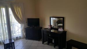 Habitación con escritorio con espejo y TV. en Ocean View Villas C10, en Port Edward
