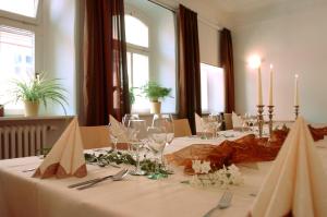 ein Esszimmer mit einem Tisch mit Weingläsern und Kerzen in der Unterkunft Gasthof Grüner Baum in Dettelbach