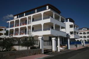 un bâtiment blanc avec une clôture devant lui dans l'établissement Hotel Yria, à Vieste