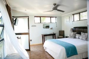 um quarto com uma cama e uma ventoinha de tecto em Princes Lodge Guesthouse em East London