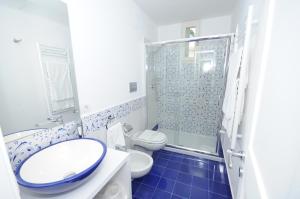 La salle de bains est pourvue de toilettes, d'un lavabo et d'une douche. dans l'établissement Maremaris B&B, à Trani