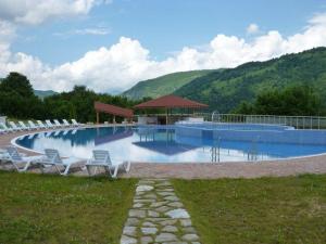 a large swimming pool with chairs and a gazebo at Park Hotel Ribaritsa in Ribarica