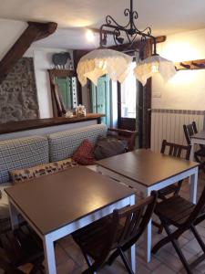 een woonkamer met 2 tafels en een bank bij B&B Boscoverde in Pievepelago +32 foto's