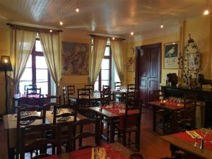 a restaurant with wooden tables and chairs and windows at Hotel Vidal in Céret
