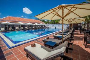 einen Pool mit Stühlen und Sonnenschirmen neben einem Pool in der Unterkunft Good Time Resort in Sihanoukville