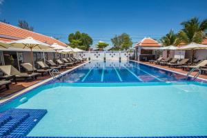a large swimming pool with chairs and umbrellas at Good Time Resort in Sihanoukville