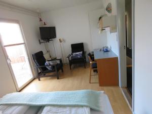 Snedsted的住宿－Stenbjerg Kro & Badehotel，客厅设有厨房、桌子和椅子