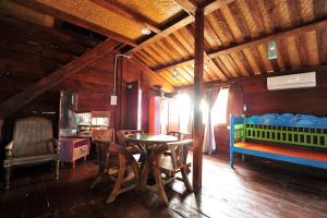 a room with a table and a bed and a table and chairs at Kapitan Lodge in Port Dickson