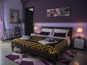 a bedroom with a large bed with purple walls at La Casa Di Luce 2 in Reggio Calabria