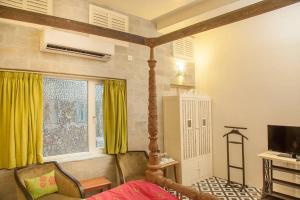 a living room with a bed and a television at The Ivy House in Kolkata
