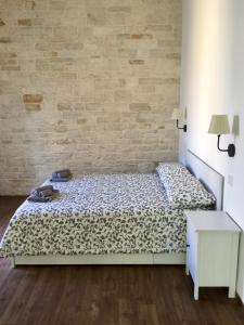 sypialnia z łóżkiem i ścianą z cegły w obiekcie B&B Sant'Agostino w mieście Giovinazzo