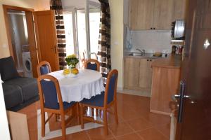 a kitchen and a table with a white table cloth at Apartman Sena in Vodice