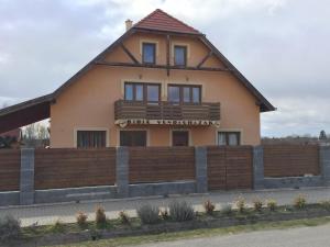 um edifício com uma cerca em frente em Bíbic Vendégházak em Nagybajom