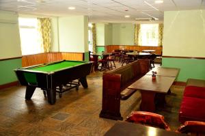 a room with a pool table and tables and chairs at Spean Bridge Hotel in Spean Bridge