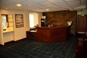 a lobby with a reception desk and a stone wall at Spean Bridge Hotel in Spean Bridge