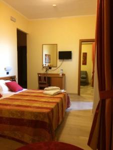 ein Hotelzimmer mit Bett und Spiegel in der Unterkunft Hotel Aurora in Vieste