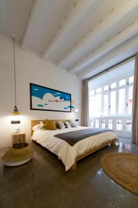 Un dormitorio con una cama grande y una ventana grande. en Welldone Cathedral, en Sevilla
