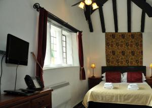 a bedroom with a bed with a telephone and a window at Old Court Hotel & Apartments in Symonds Yat