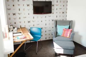 Zimmer mit einem Schreibtisch, einem Stuhl und einem TV in der Unterkunft bei Kliewe im Westfälischen Hof in Beckum