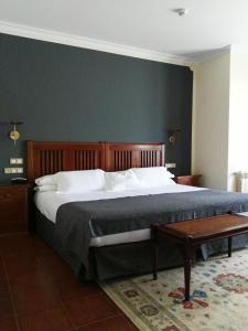 a large bed in a bedroom with a green wall at Hotel Finca La Mansión in Llanes