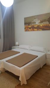 a bedroom with a white bed with a painting on the wall at Pension Yna Holiday in Málaga