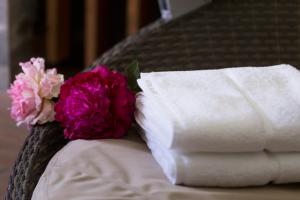 uma pilha de toalhas e flores numa cama em Hotel Plant Garden Resort (Adult Only) em Toyokawa
