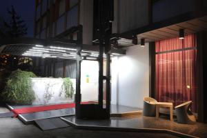 a building with a sliding glass door with a chair at Hotel Ariane in Thiene