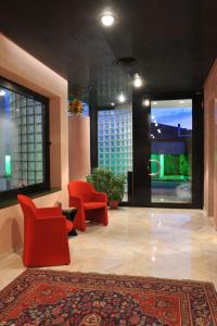 a lobby with two red chairs and a rug at Hotel Ariane in Thiene