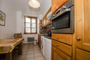 een keuken met een tafel en een magnetron bij Appartement Lavande in Chamonix-Mont-Blanc