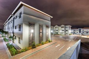 un bâtiment dans un parking la nuit dans l'établissement Savannah Park Luxury Apartments, à Durban