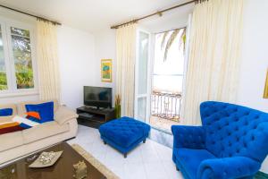 a living room with a couch and chairs and a tv at Holiday Home Obrov in Kaštela