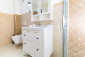 a bathroom with a white sink and a toilet at Holiday Home Obrov in Kaštela +26 photos