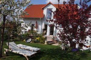 巴特溫茨海姆的住宿－Karuna Haus，院子里有长凳的白色房子
