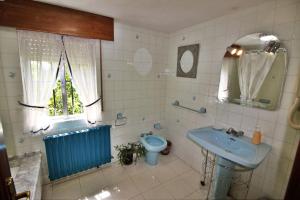 łazienka z błękitną umywalką i toaletą w obiekcie Casa Cunha w mieście Cornanda +37 zdjęć