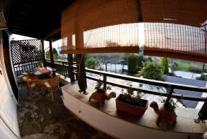 a balcony with potted plants sitting on a ledge at Near Paradise in Koropi
