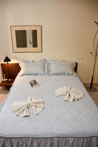 a bed with two white bows on it at Near Paradise in Koropi