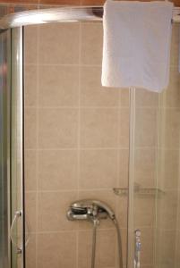 a shower with a glass door and a white towel at Near Paradise in Koropi +25 photos