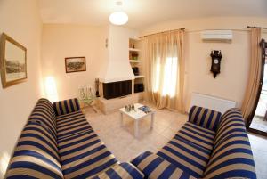 a living room with a couch and a tv at Near Paradise in Koropi