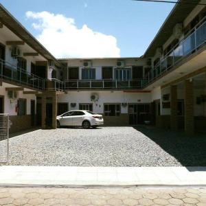 a car parked in a parking lot in front of a building at Hotel Anjo Gabriel in Penha